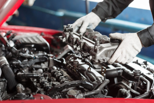 Repairing of modern diesel engine, workers hands and tool. Car mechanic looking at engine for analysis symptoms of car at maintenance repair service station