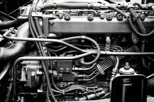 A classic fragment of diesel car engine or truck engine with copy space for text. Metallic background of the internal diesel truck engine or car engine.